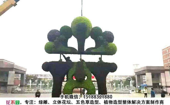吊车正在吊装四川成都脸谱五色草造型雕塑